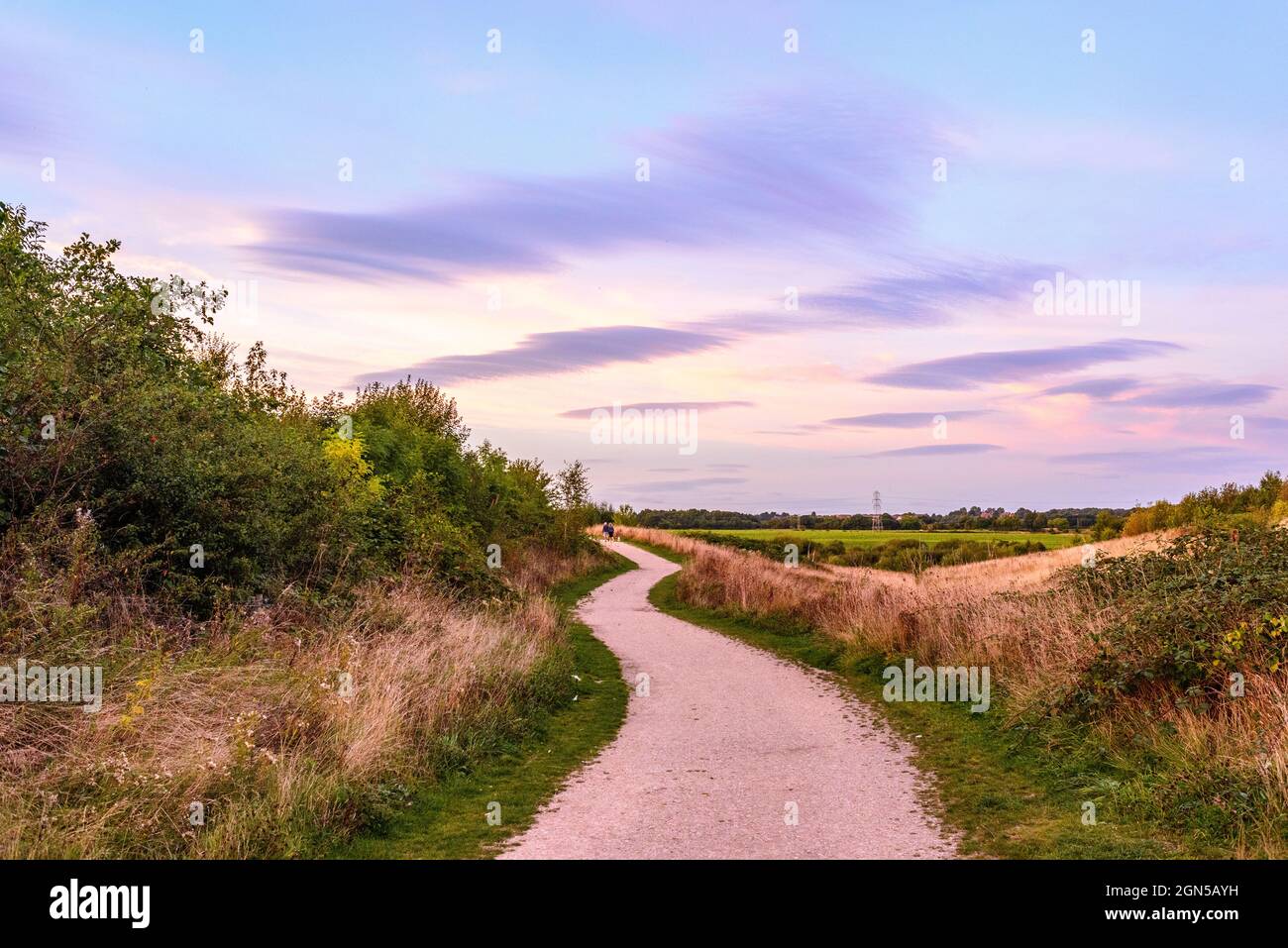 Royston, Barnsley, South Yorkshire, UK, 22nd September 2021, Weather. Illuminated cloud formations at sunset over Rabbit Ings Country Park. The warm and dry spell continues into the autumn season. Credit: Paul Biggins/Alamy Live News Stock Photo