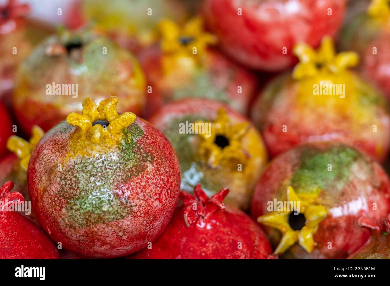 brightly painted ceramic pomegranate on display at a pottery and