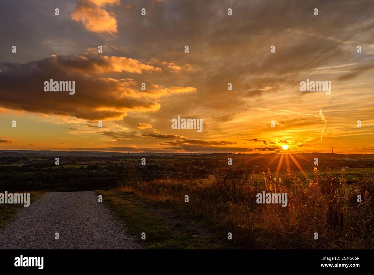Royston, Barnsley, South Yorkshire, UK, 22nd September 2021, Weather. Illuminated cloud formations at sunset over Rabbit Ings Country Park. The warm and dry spell continues into the autumn season. Credit: Paul Biggins/Alamy Live News Stock Photo