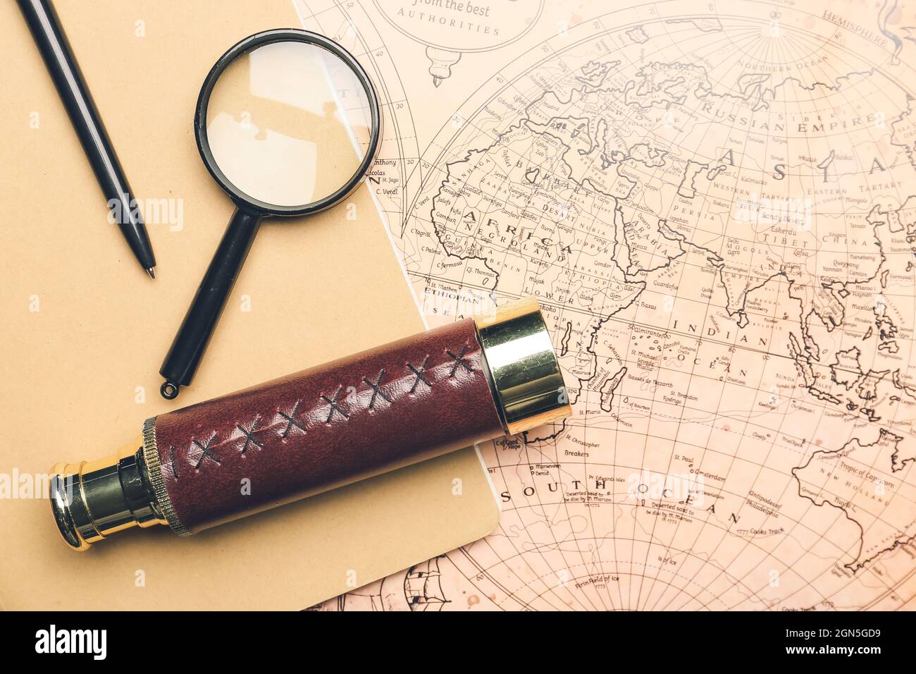 Old spyglass with magnifier and notebook on vintage world map Stock ...