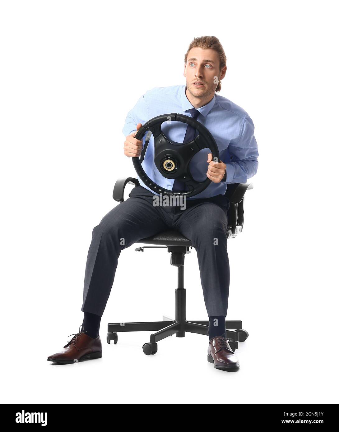 Young man with steering wheel sitting on chair against white background