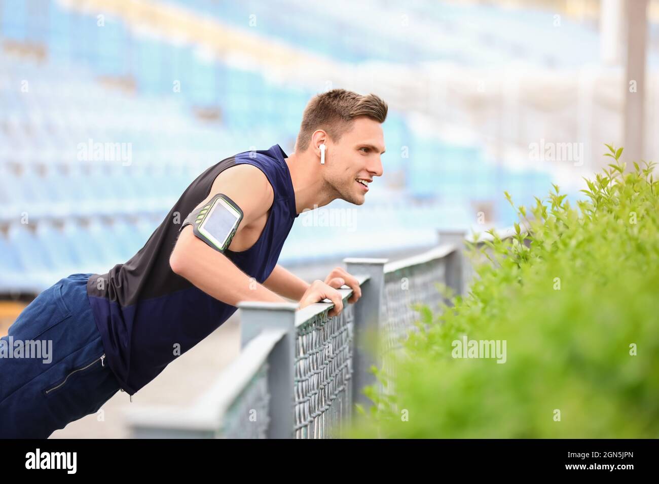 Sporty young man doing push ups at stadium Stock Photo - Alamy