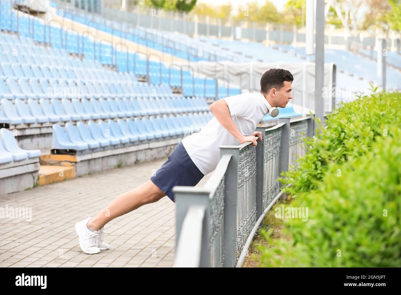 Sporty young man doing push ups at stadium Stock Photo - Alamy