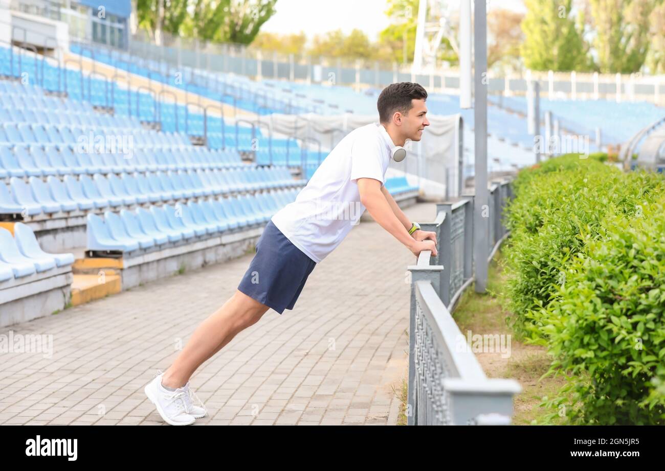 Sporty young man doing push ups at stadium Stock Photo - Alamy
