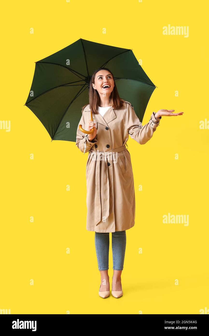 Beautiful young woman with umbrella on color background Stock Photo - Alamy