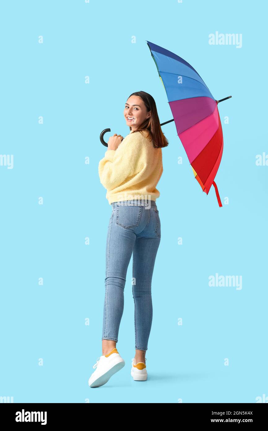 Beautiful young woman with umbrella on color background Stock Photo - Alamy
