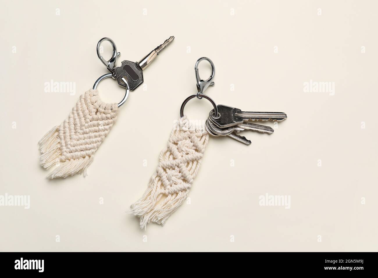 Keys with handmade cotton keychains on light background Stock Photo