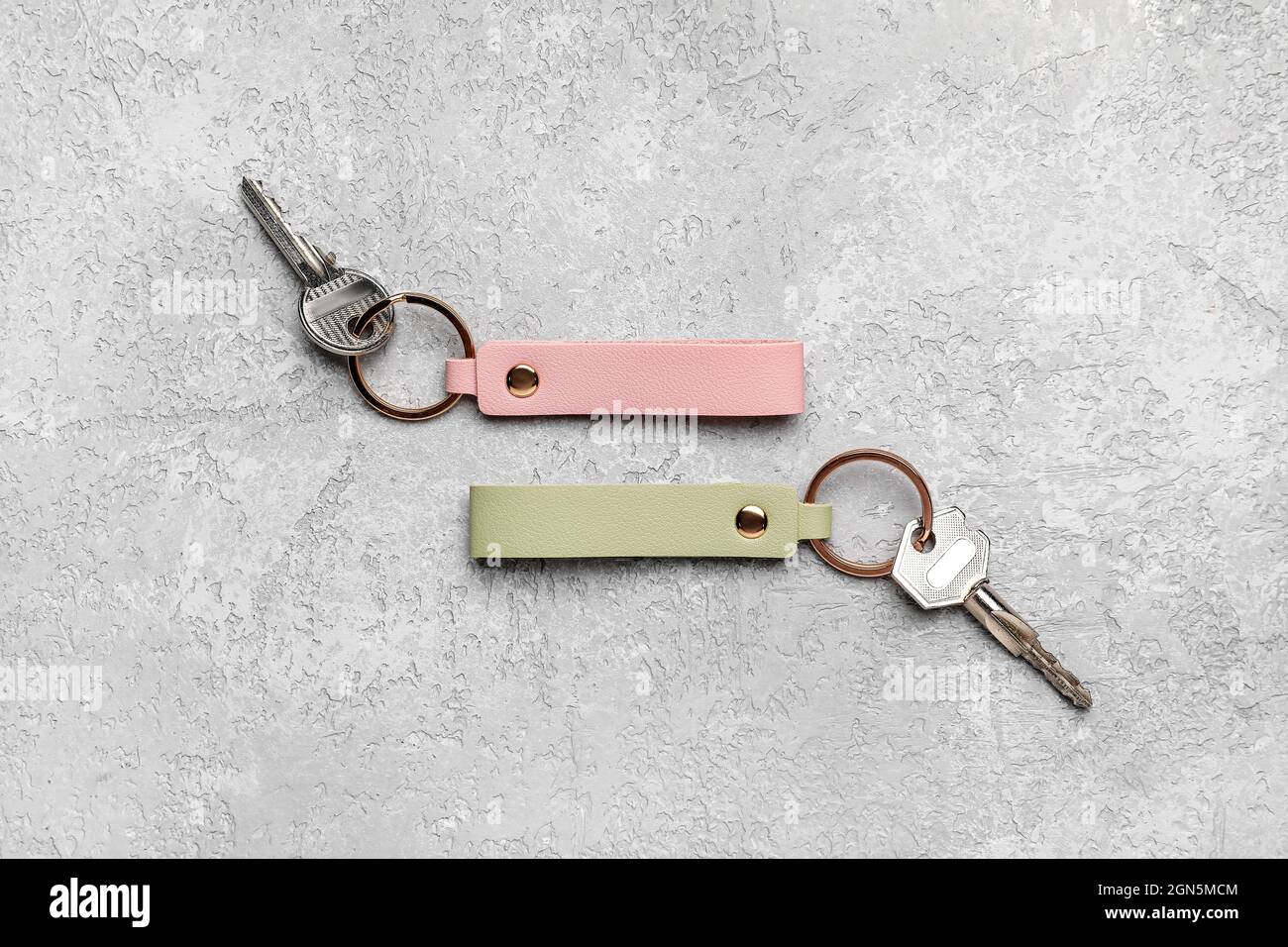 Keys with leather keychains on grey background Stock Photo
