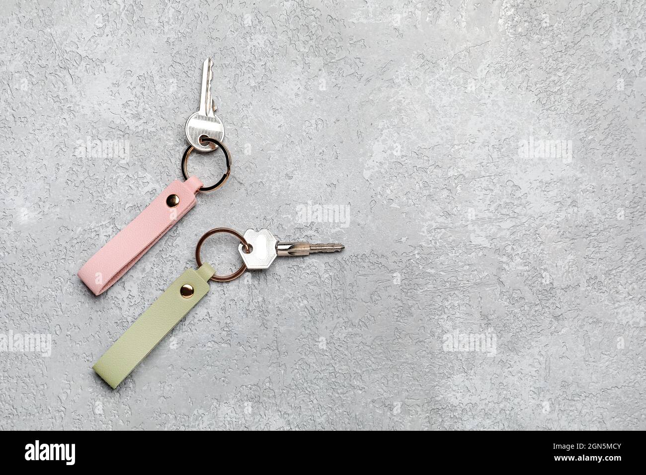 Keys with leather keychains on grey background Stock Photo