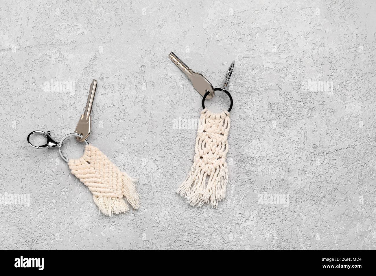 Keys with handmade cotton keychains on grey background Stock Photo