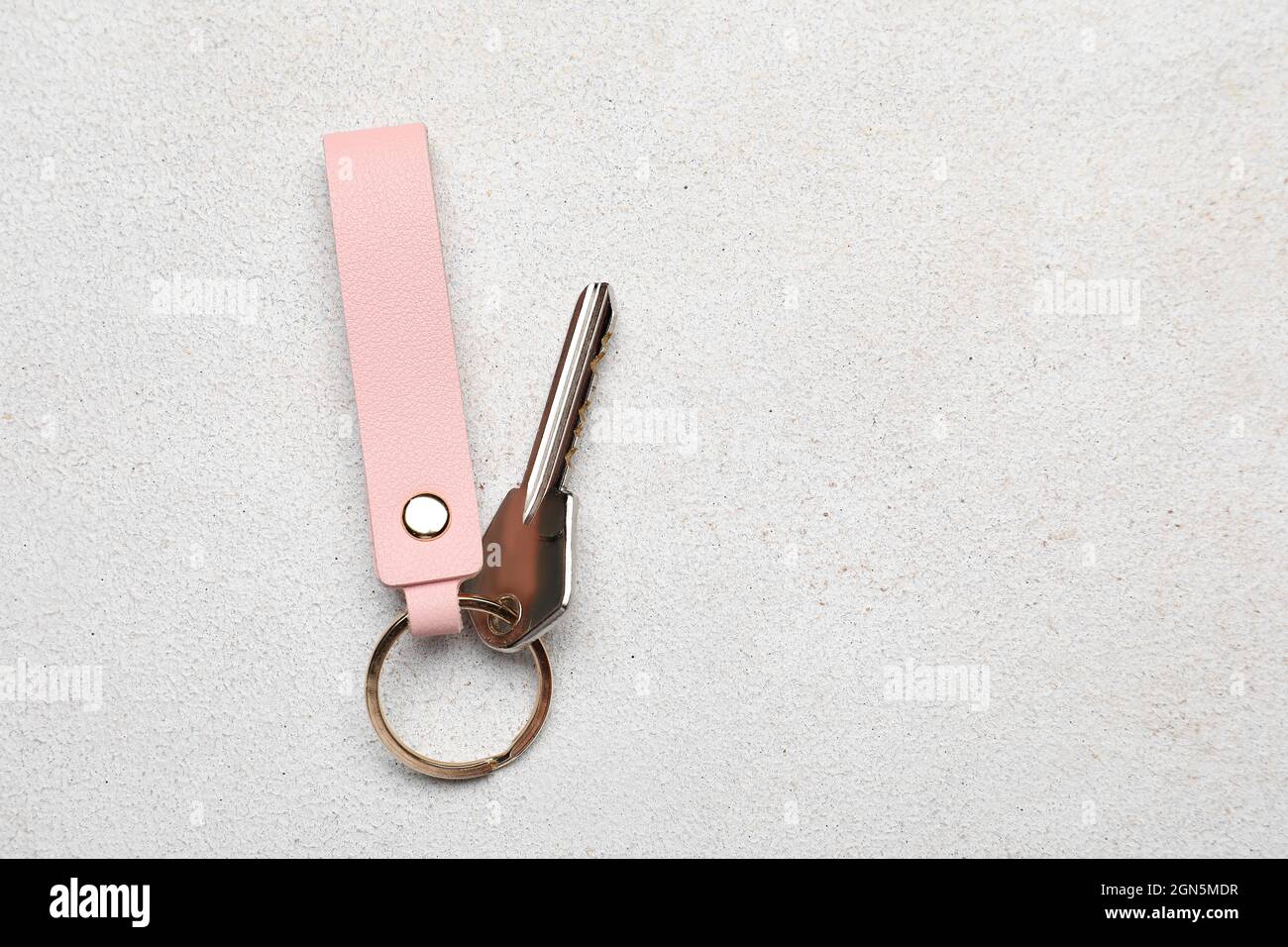 Key with leather keychain on light background Stock Photo