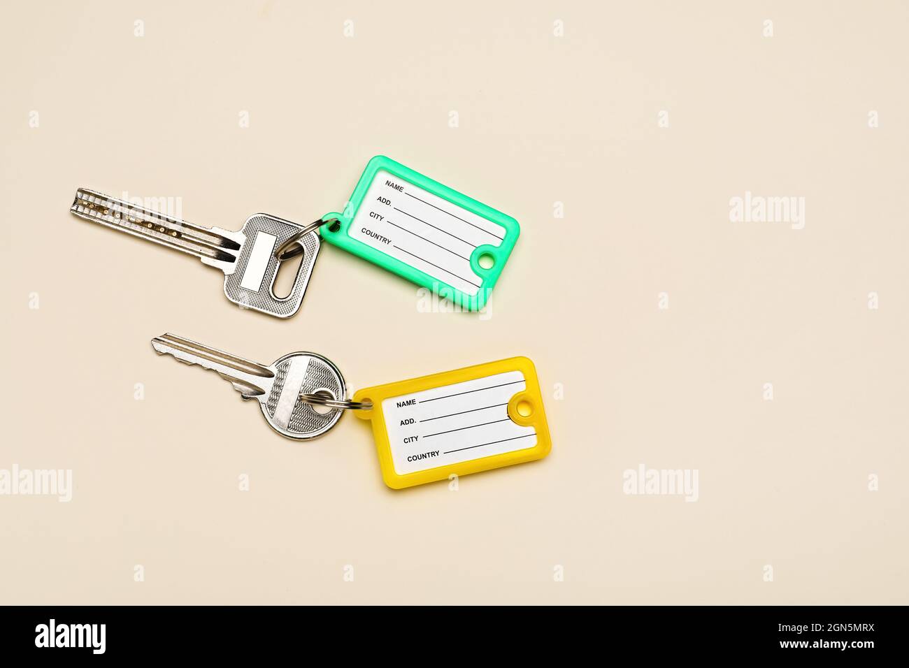Keys with plastic tags on beige background Stock Photo