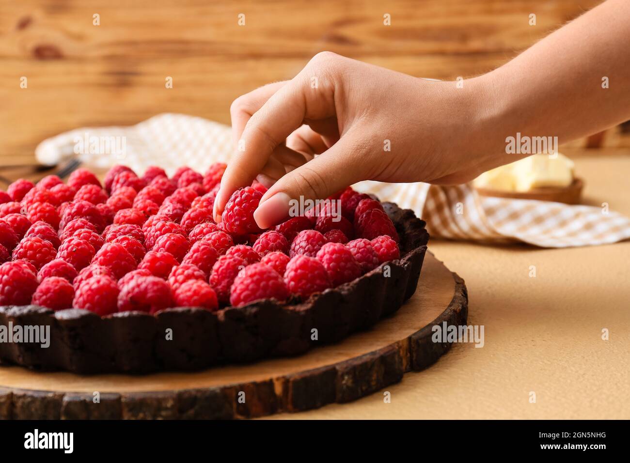 Woman decorating tasty raspberry pie on color table, closeup Stock ...