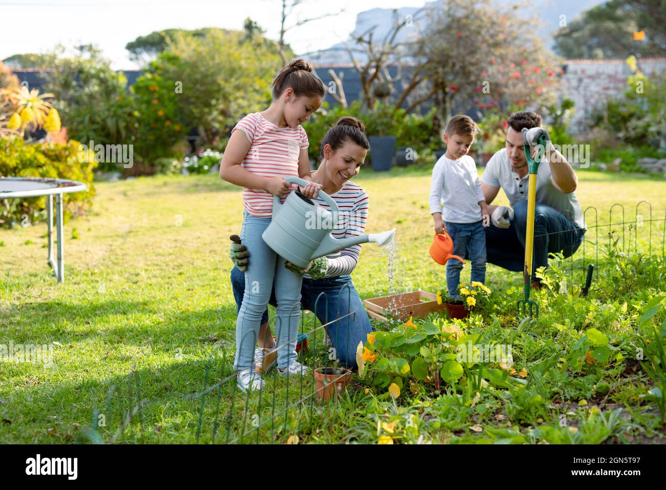 Happy caucasian family gardening and watering plants together Stock ...