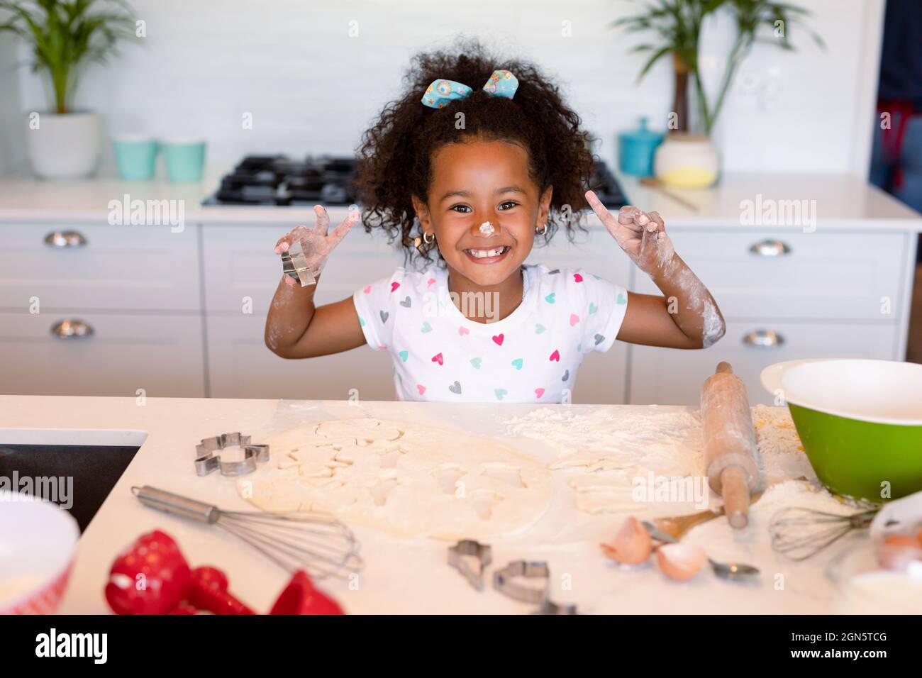 Happy african american messy girl baking in kitchen Stock Photo