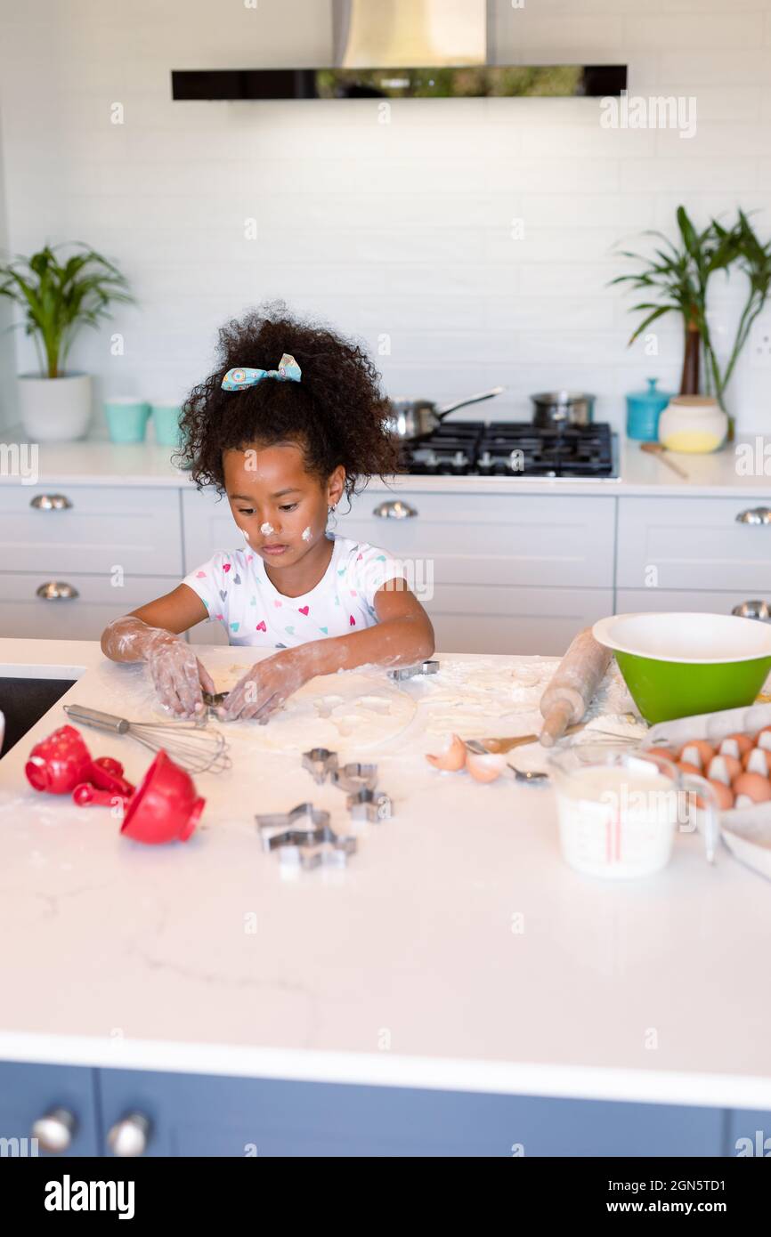 Focused african american messy girl baking in kitchen Stock Photo