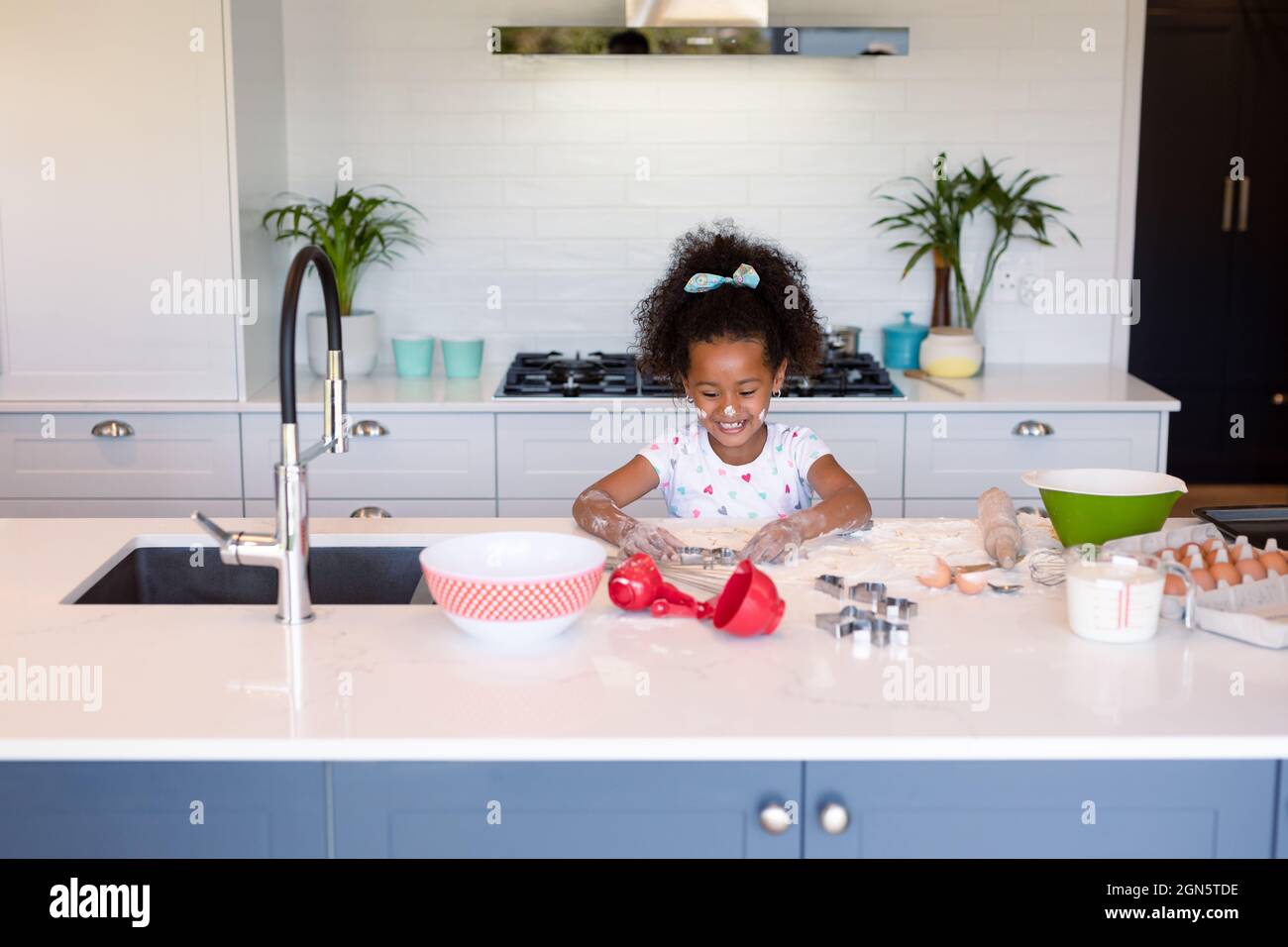 Happy african american messy girl baking in kitchen Stock Photo