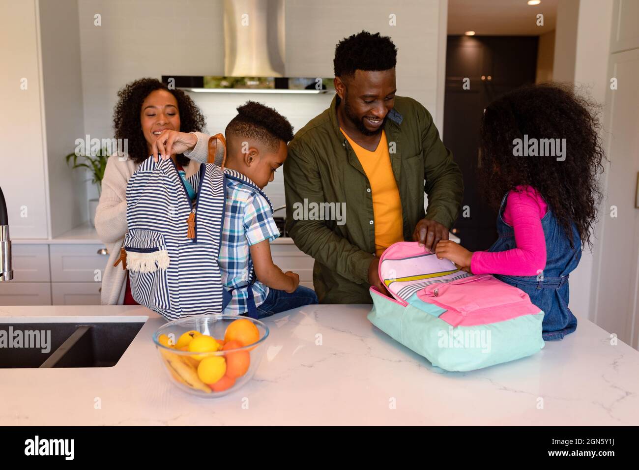 Happy african american parents and children preparing backpacks for school Stock Photo