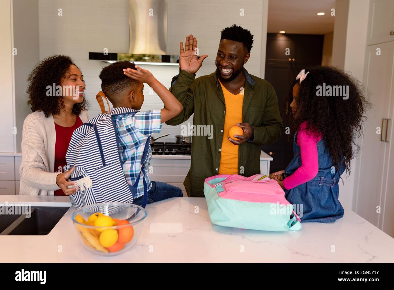 Happy african american parents and children preparing backpacks for school Stock Photo