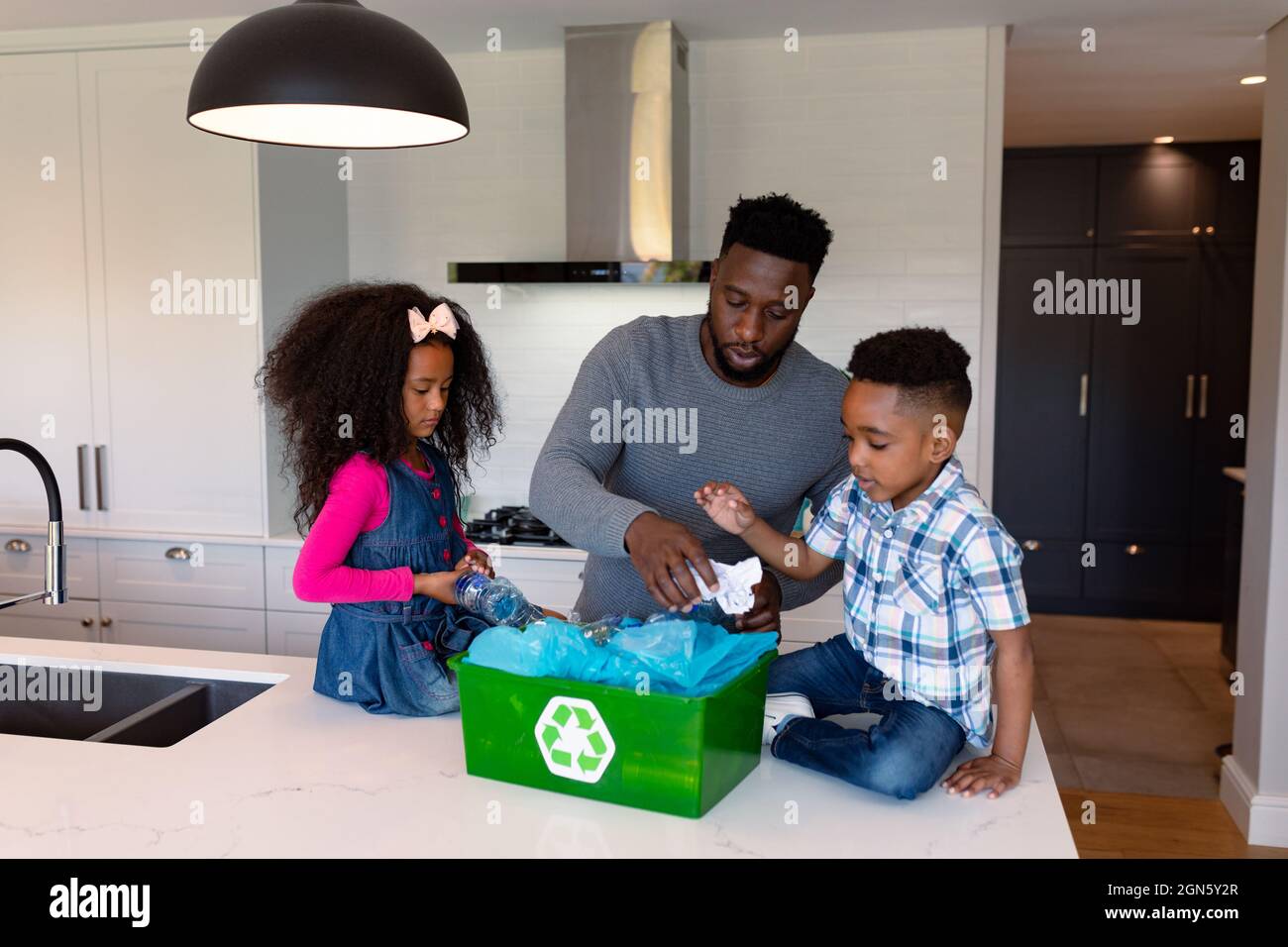 African american father and children segregating rubbish in kitchen Stock Photo