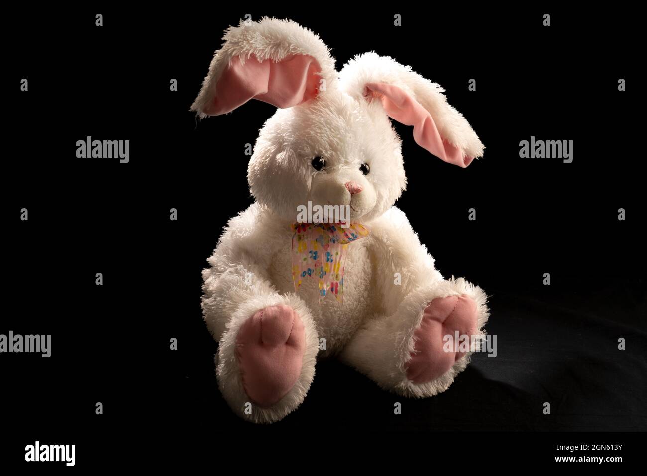 Low key lighting of a stuffed rabbit with lop-sided ears Stock Photo