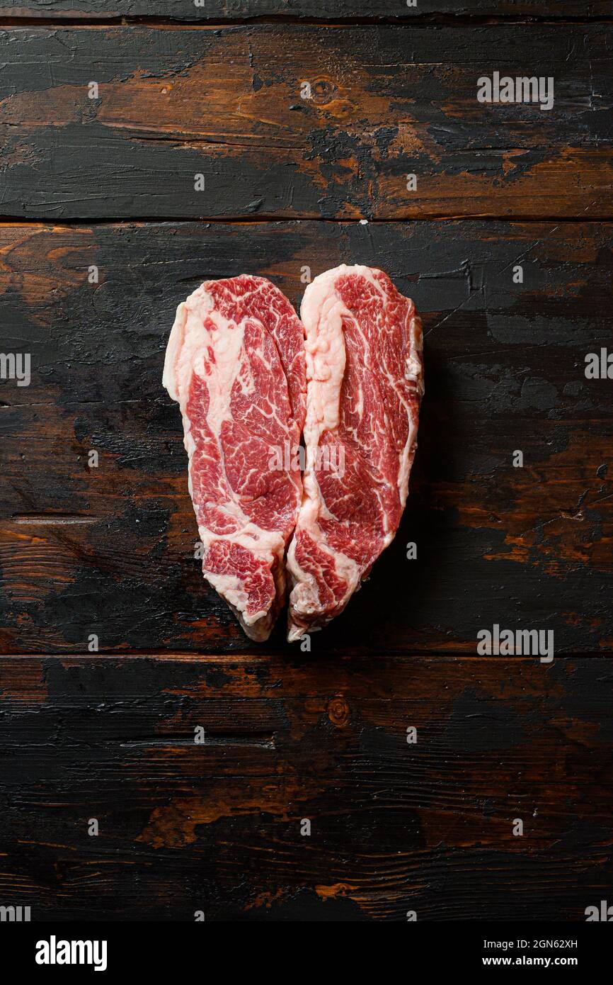 Heartshape Raw Chuck eye roll steak on vintage dark wood table Organic