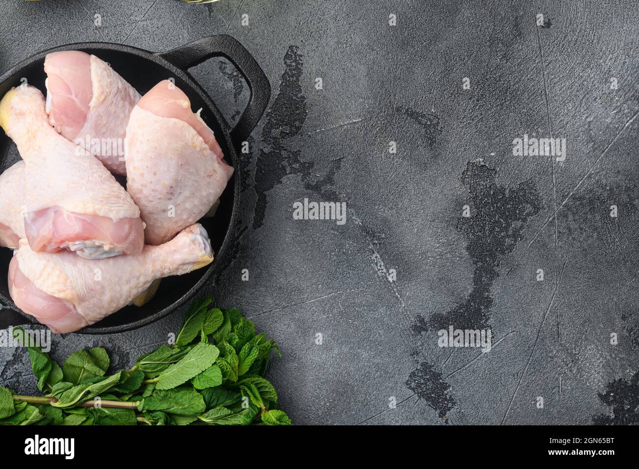 Raw meat. Chicken legs, drumsticks cuts set, on frying cast iron pan