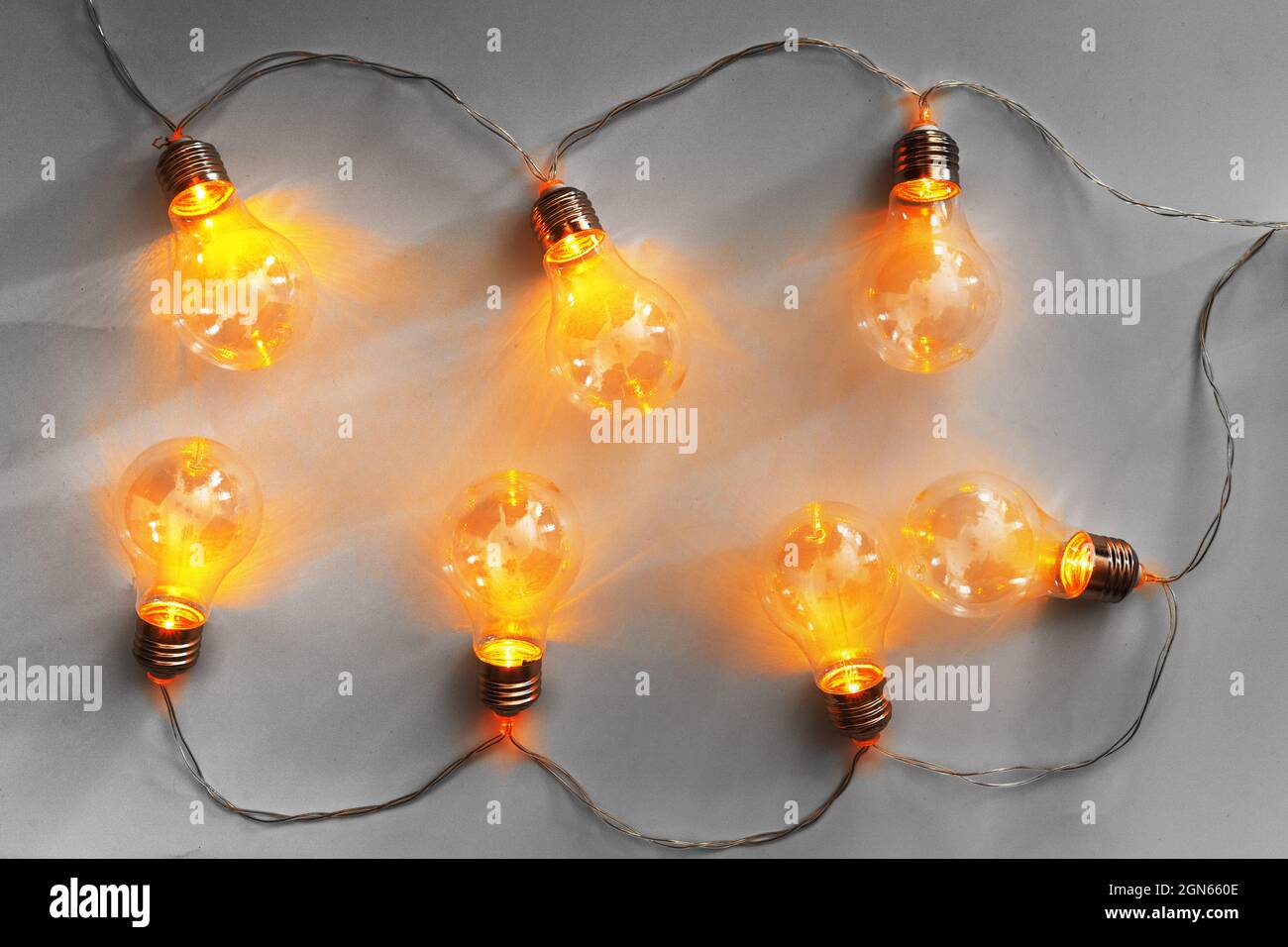 Light bulbs illuminated garland on light gray background Stock Photo