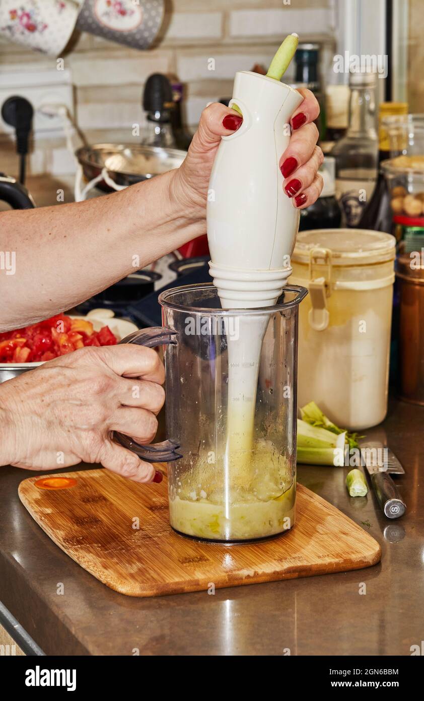 Cook grinds the puree fennel with hand blender. Stock Photo