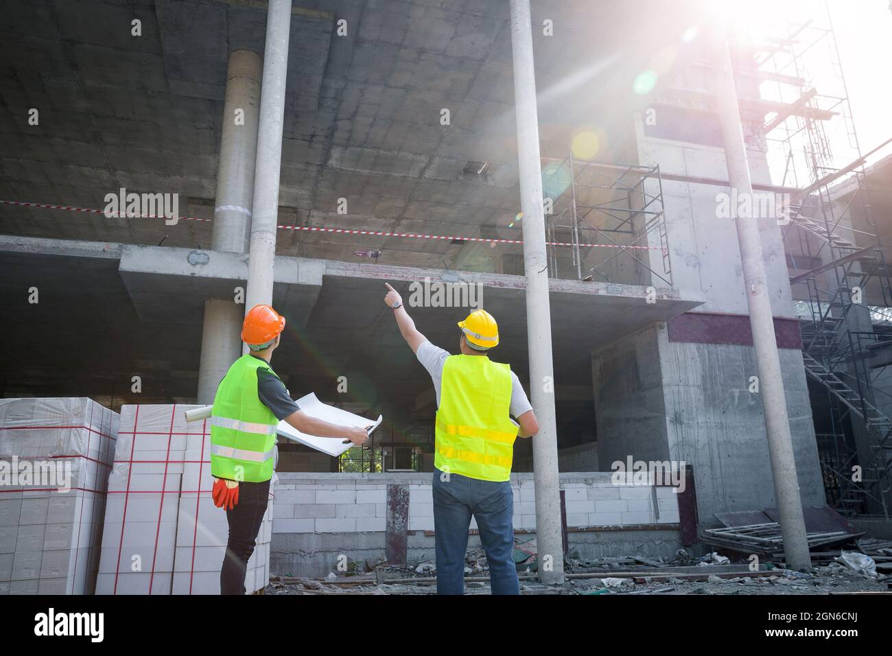 Engineer discussing with foreman about project in building construction site. Stock Photo