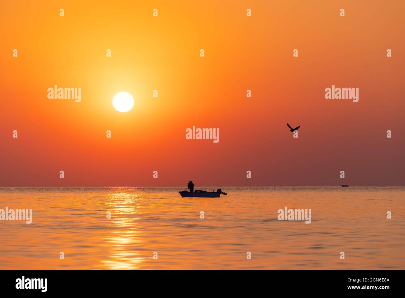 Silhouette of fisherman in a boat and norning sunrise Stock Photo - Alamy