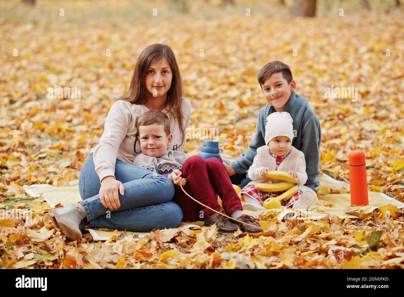 Happy family at autumn leaves park. Mother with three kids Stock Photo ...