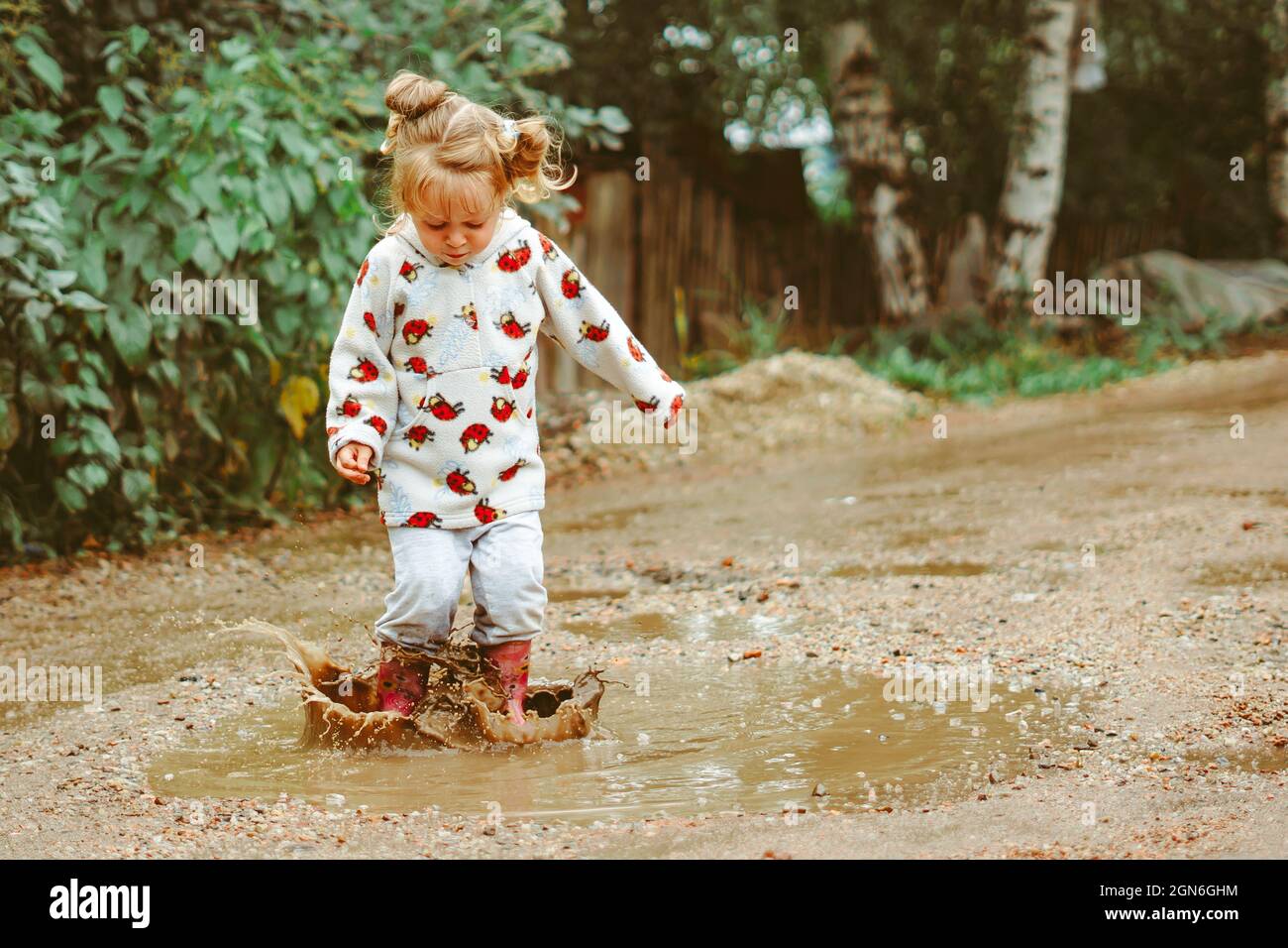 a child runs through puddles in rubber boots Stock Photo - Alamy