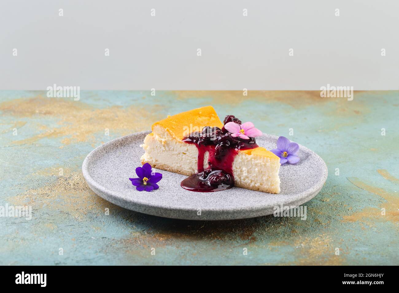 cheesecake with berry jam decorated with edible flowers Stock Photo