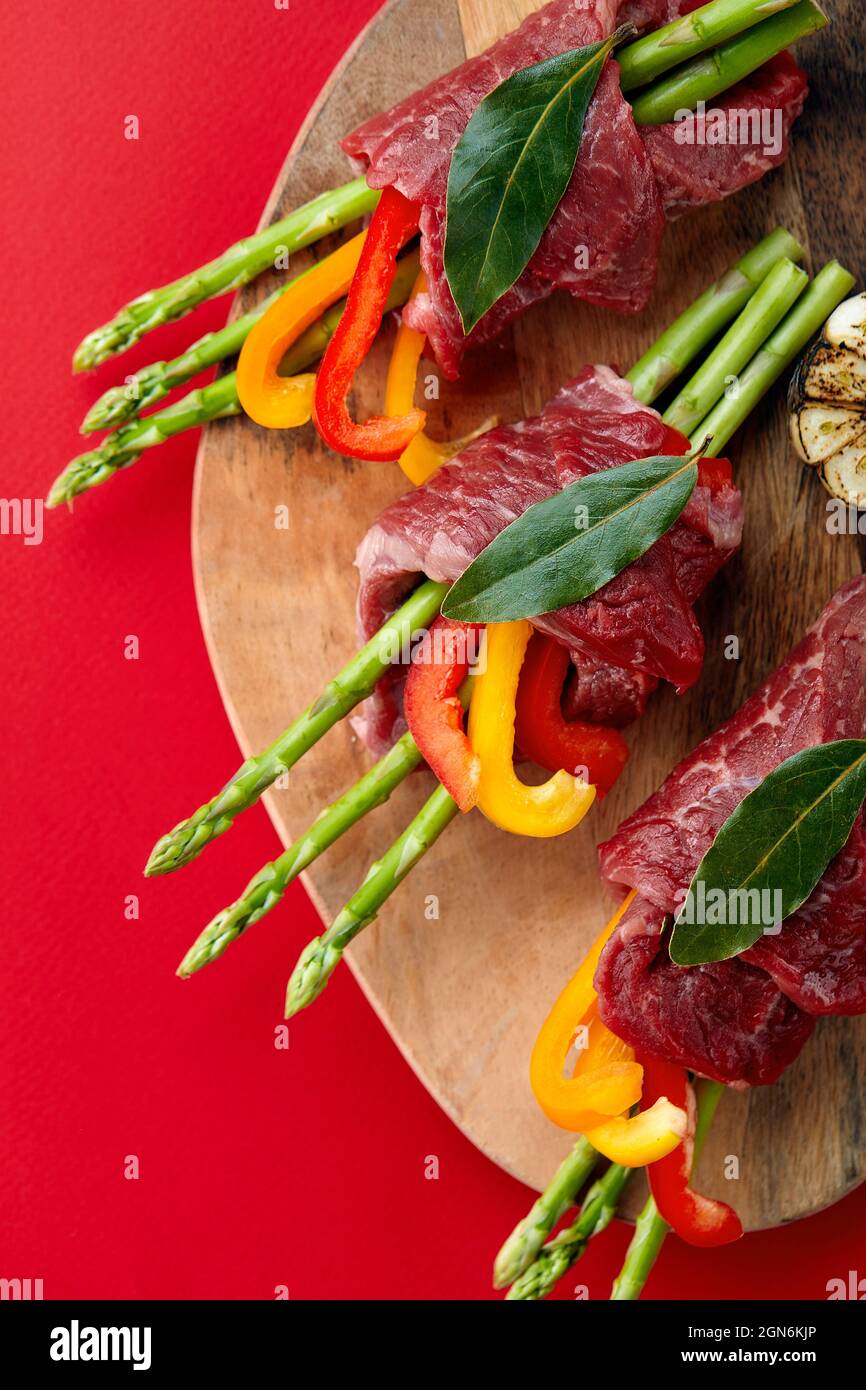 raw beef roulades and fresh vegetable trimmings ready for cooking on a