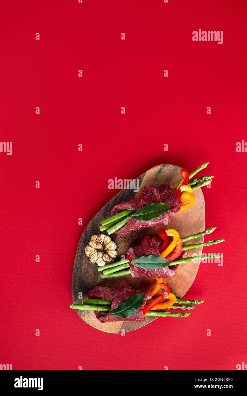 raw beef roulades and fresh vegetable trimmings ready for cooking on a