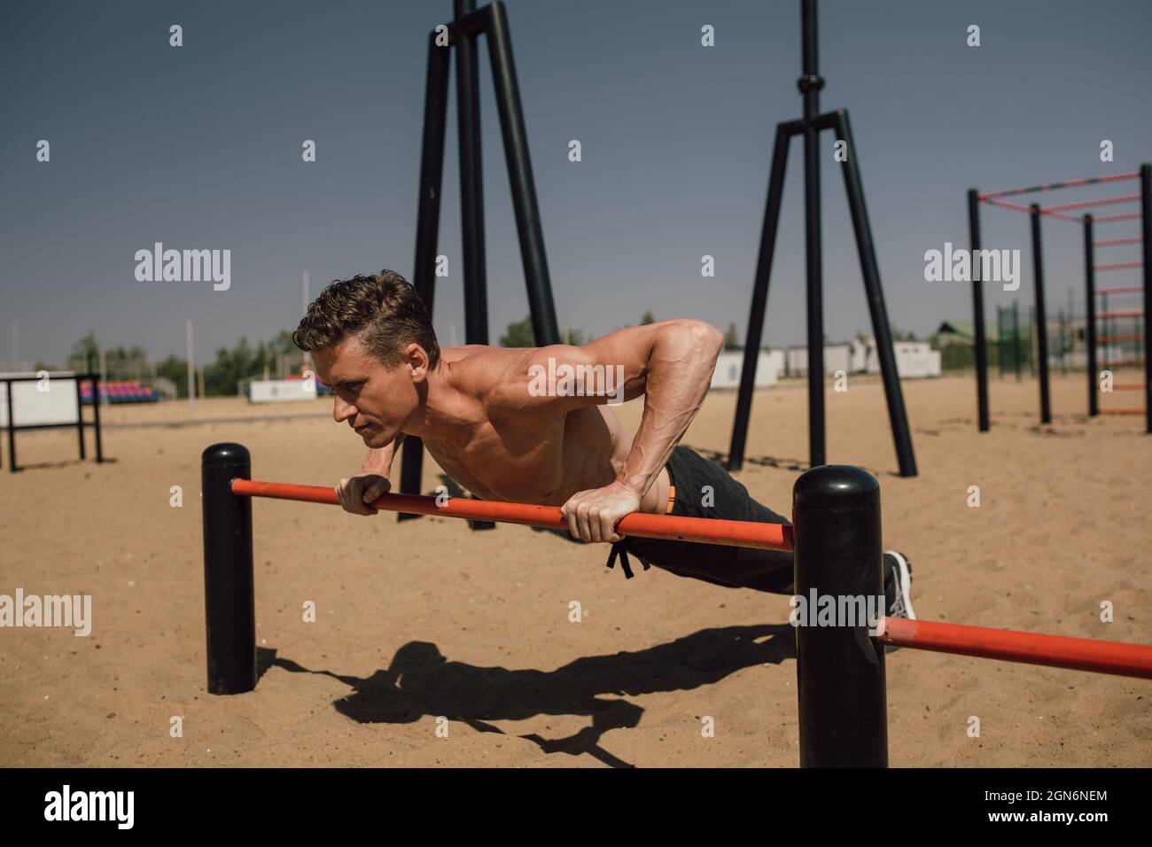 fitness, sport, training and lifestyle concept - young man exercising handstand on bar outdoors - calisthenics Stock Photo