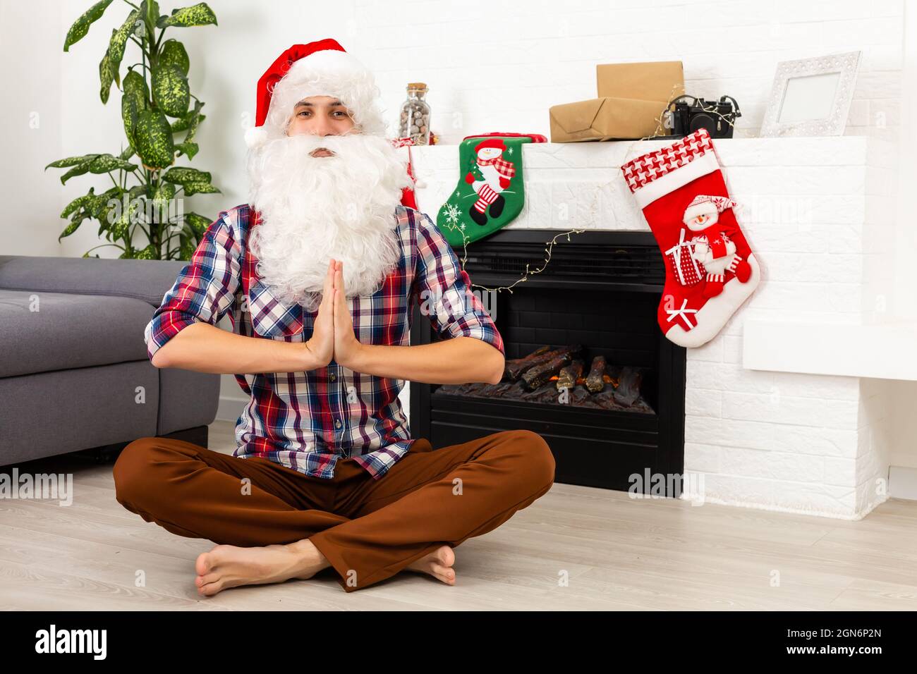 Santa Claus sits and meditates against the fireplace Stock Photo