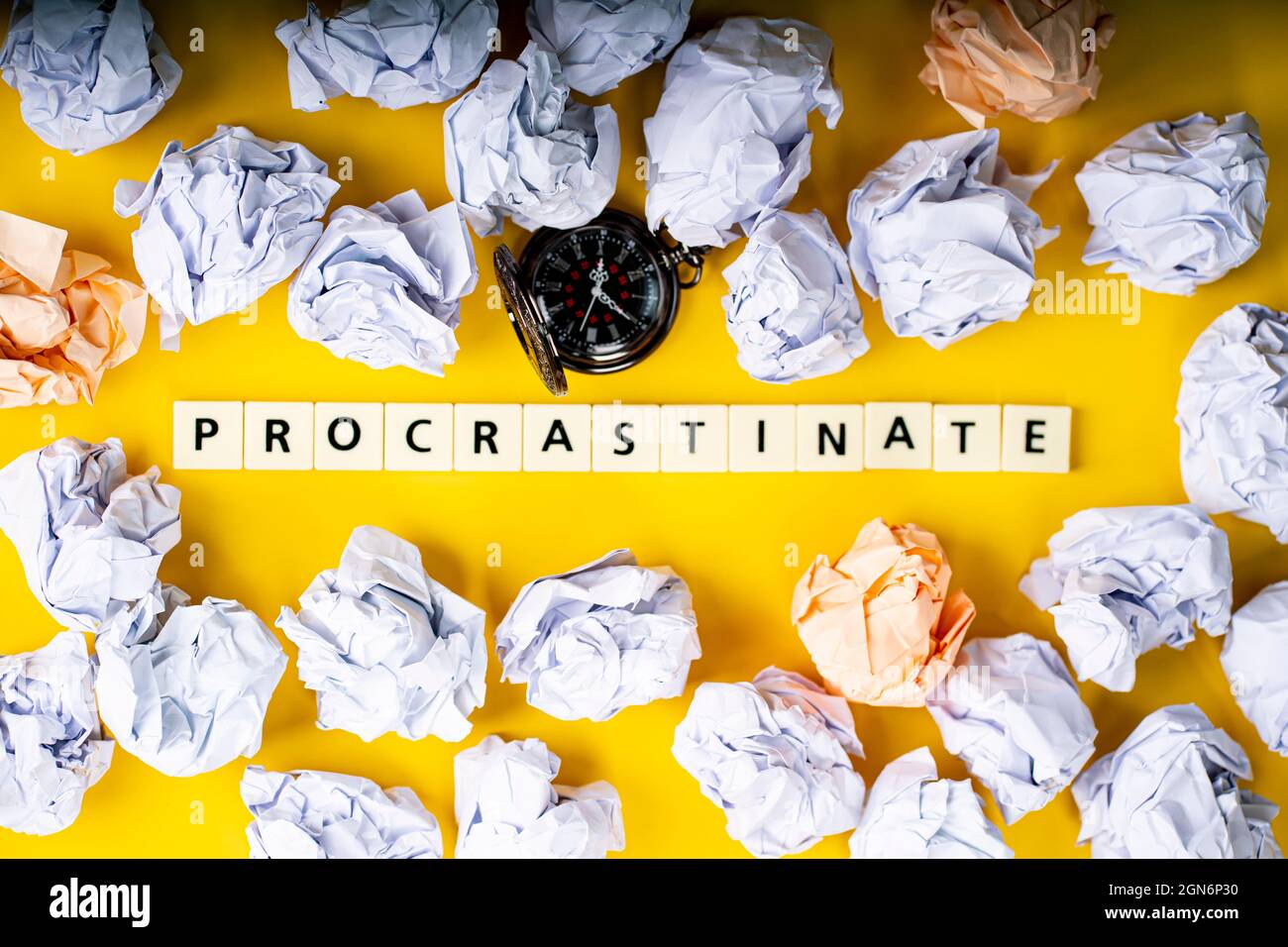 Business concept. Layout of pocket watch, crumpled papers and tiles with text procrastinate Stock Photo