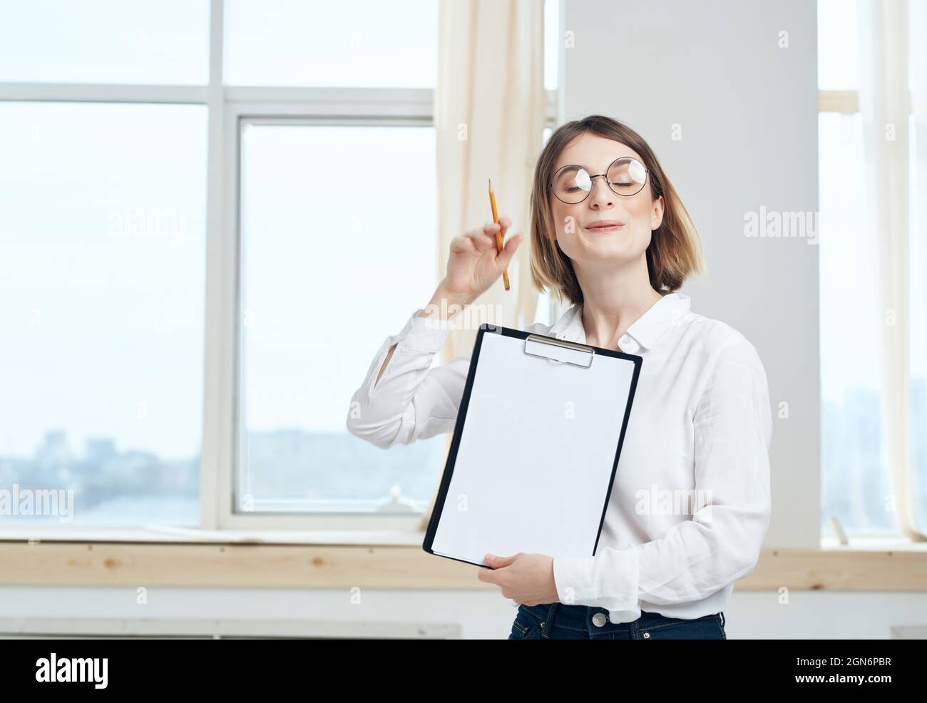 Business woman in white shirt and glasses near office manager window ...