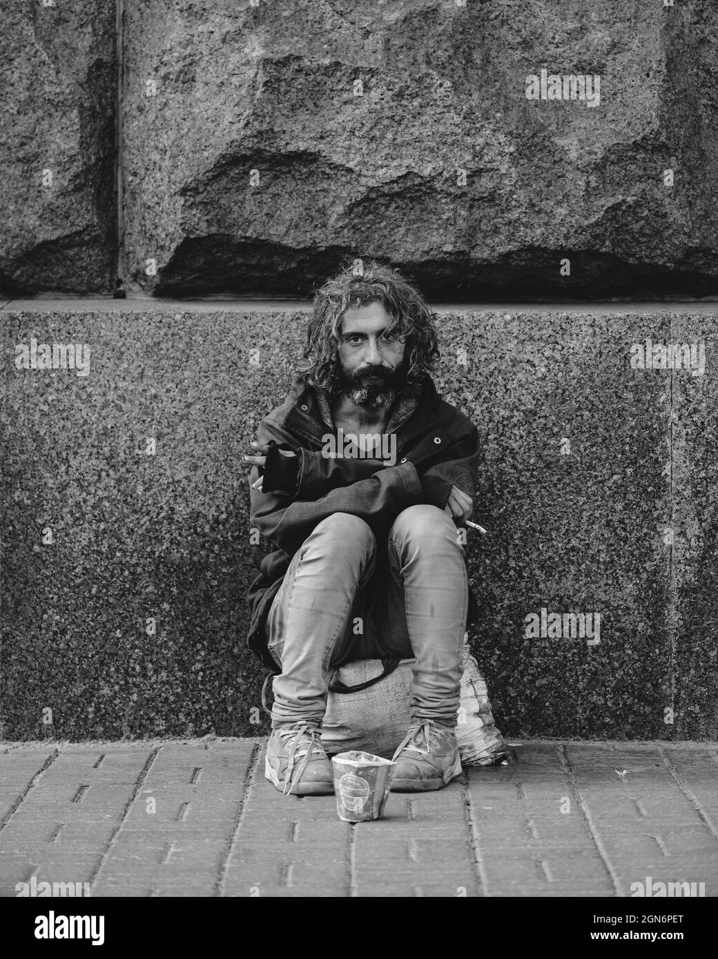 Kyiv, Ukraine - September 14, 2021: Homeless man sitting outdoors and begging. Sad depressed beggar looking at the camera Stock Photo