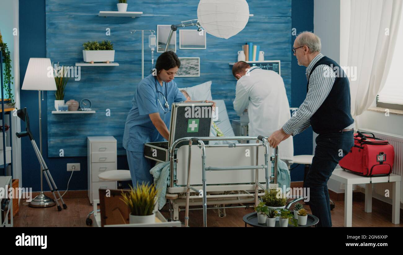 Worried man asking medical team to help sick old wife in nursing home ...