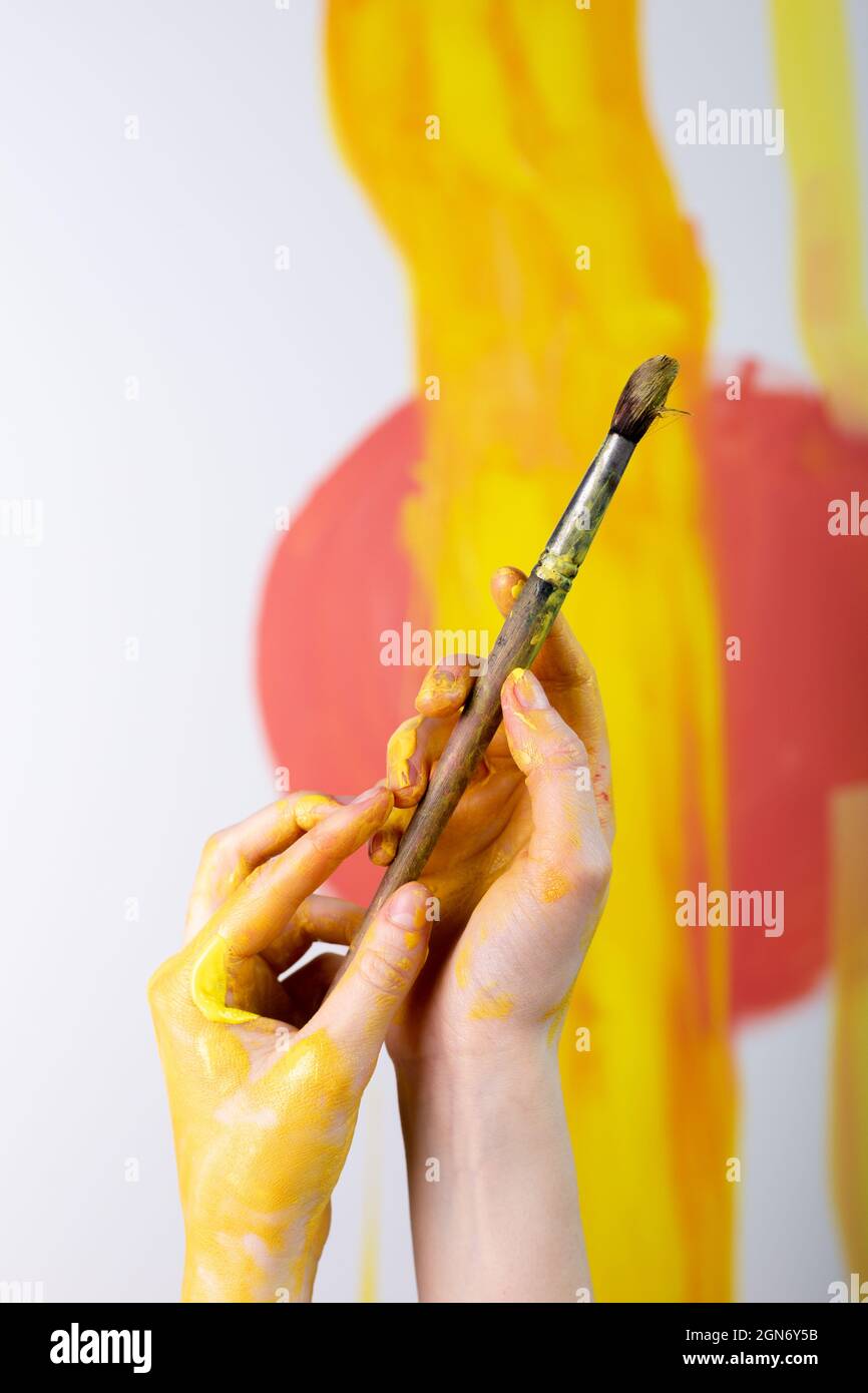 Female hands hold paint brushes. Painting a picture on an easel Stock