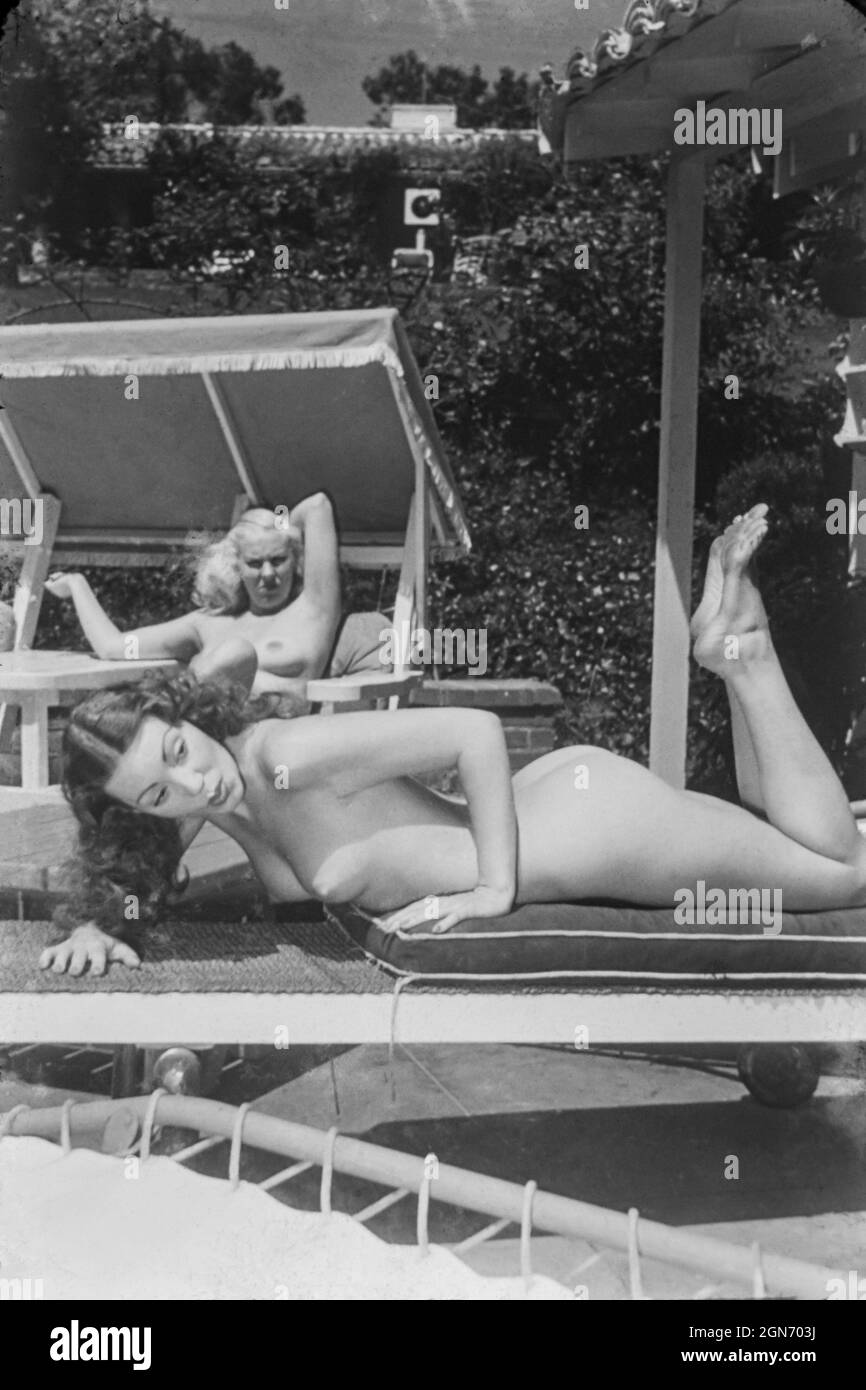 1940s / 1950s nude glamour models on sun loungers Stock Photo