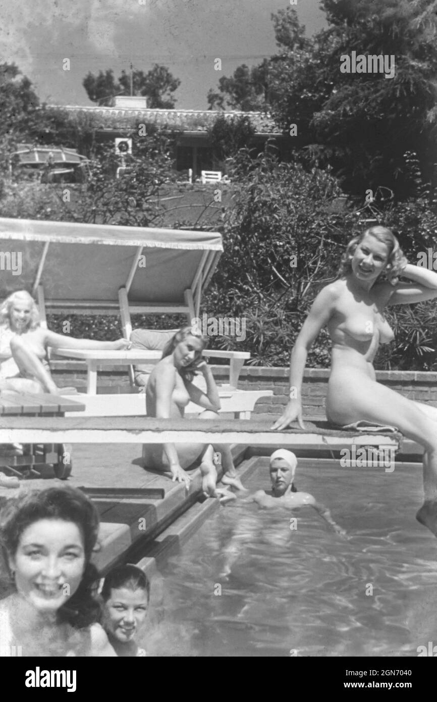 1940s / 1950s nude glamour models by a swimming pool Stock Photo