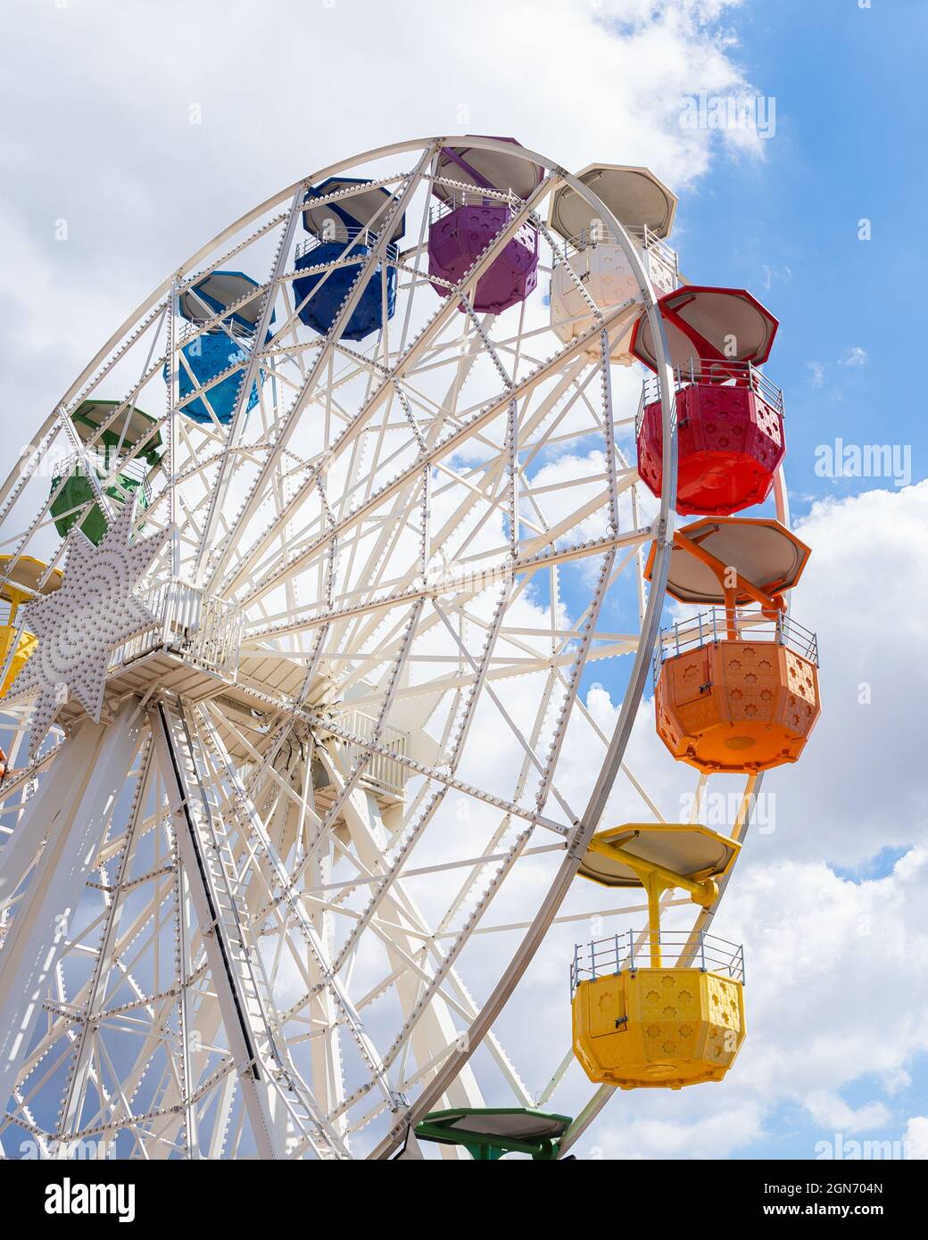 Colorful ferris wheel on a shiny day with some clouds in the background ...