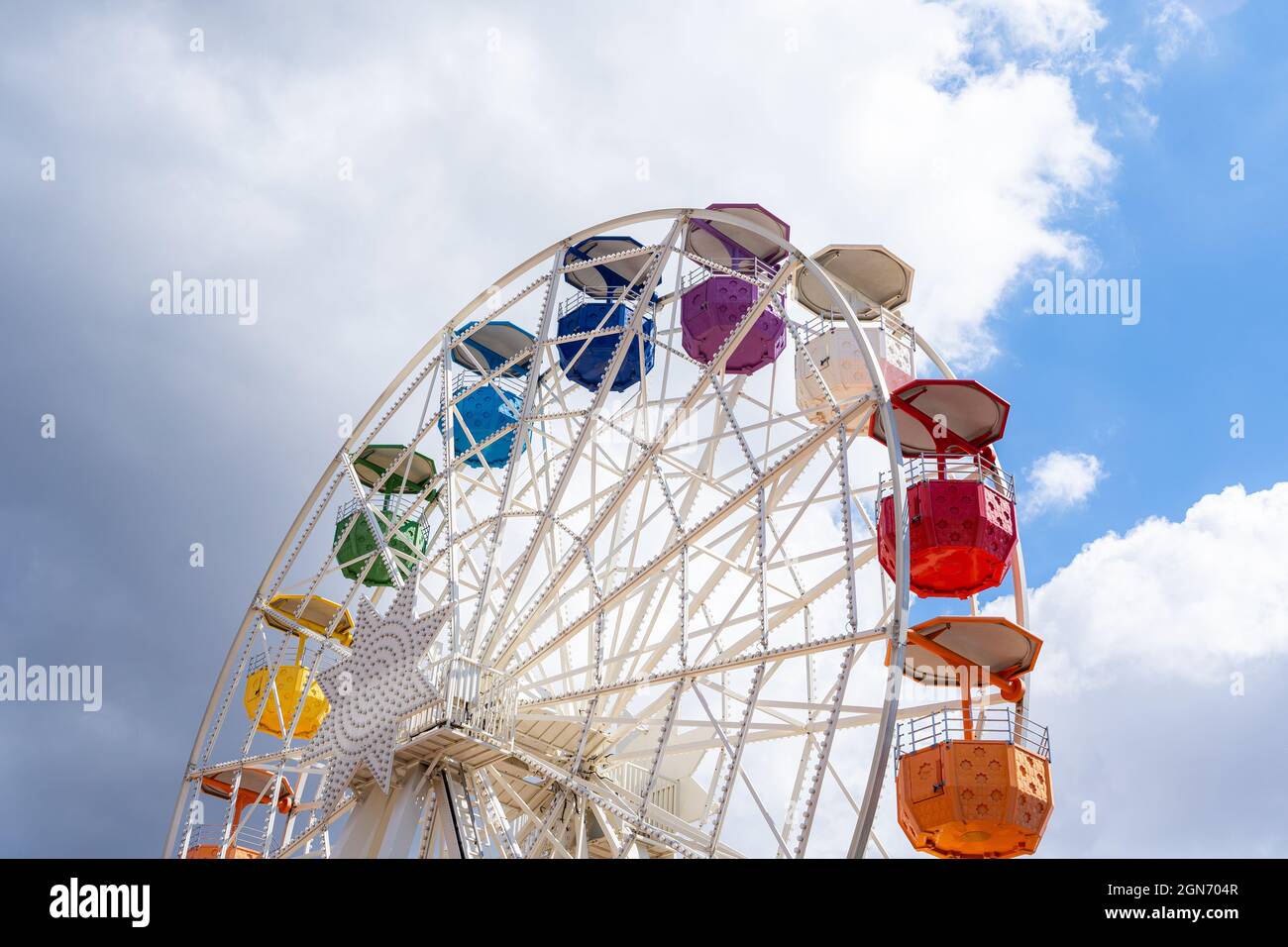 Colorful ferris wheel on a shiny day with some clouds in the background ...