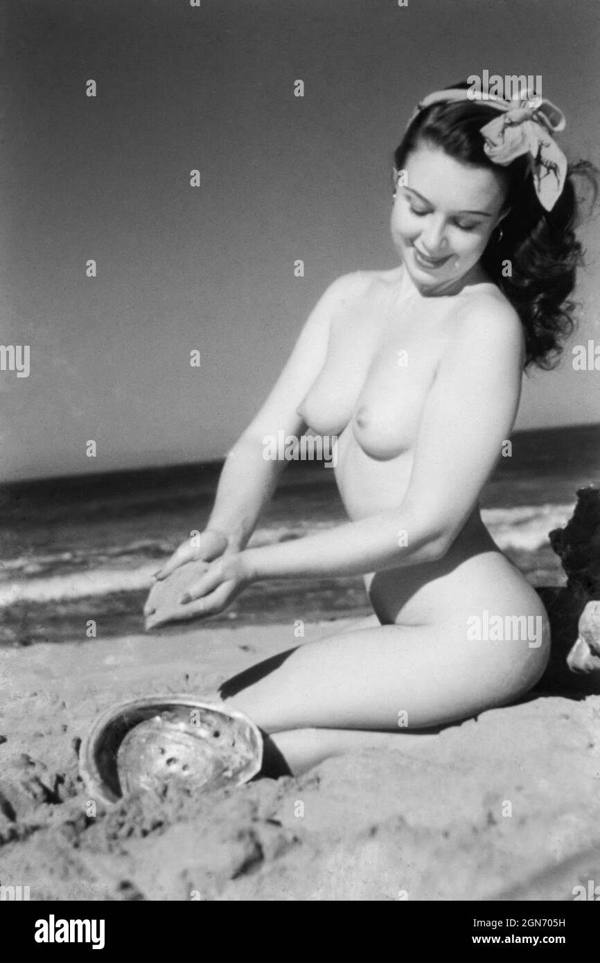 1940s / 1950s nude glamour model on a beach Stock Photo