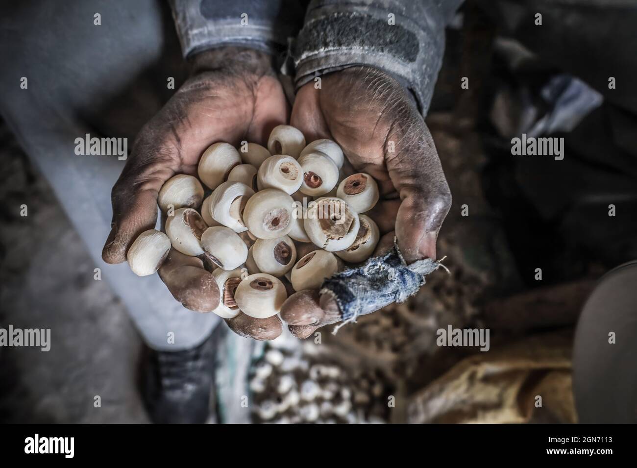 Keneth Ochuodho (40) holds unfinished round beads made from recycled ...