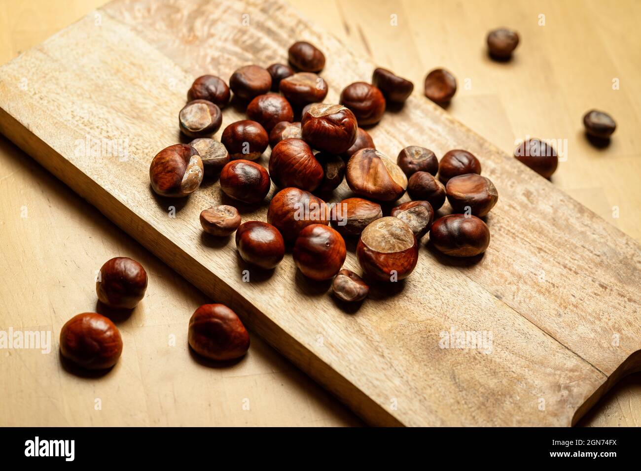 Fresh sweet edible chestnuts on wooden table Stock Photo